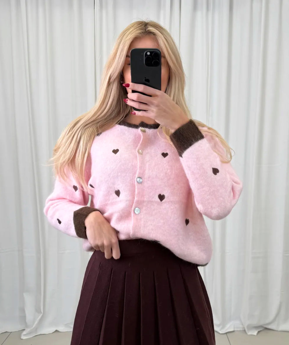 Rosa flauschige Strickjacke mit braunen Herzdetails und Knopfleiste vorne.