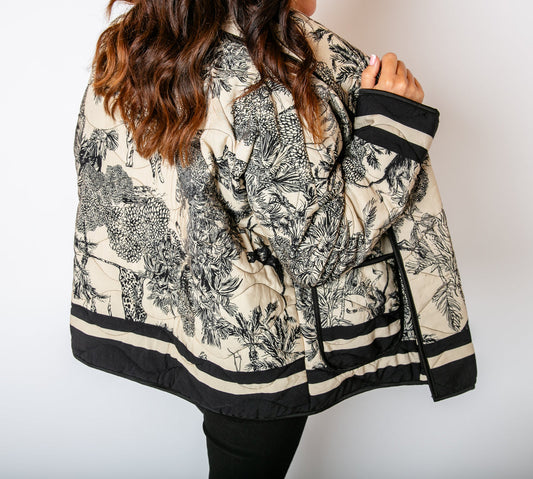 Exklusive Steppjacke in schwarz-Weiß mit elegantem Toile-de-Jouy Safari-Design. Hochwertig gesteppt, modern geschnitten und ein stilvoller Blickfang für trendbewusste Looks.