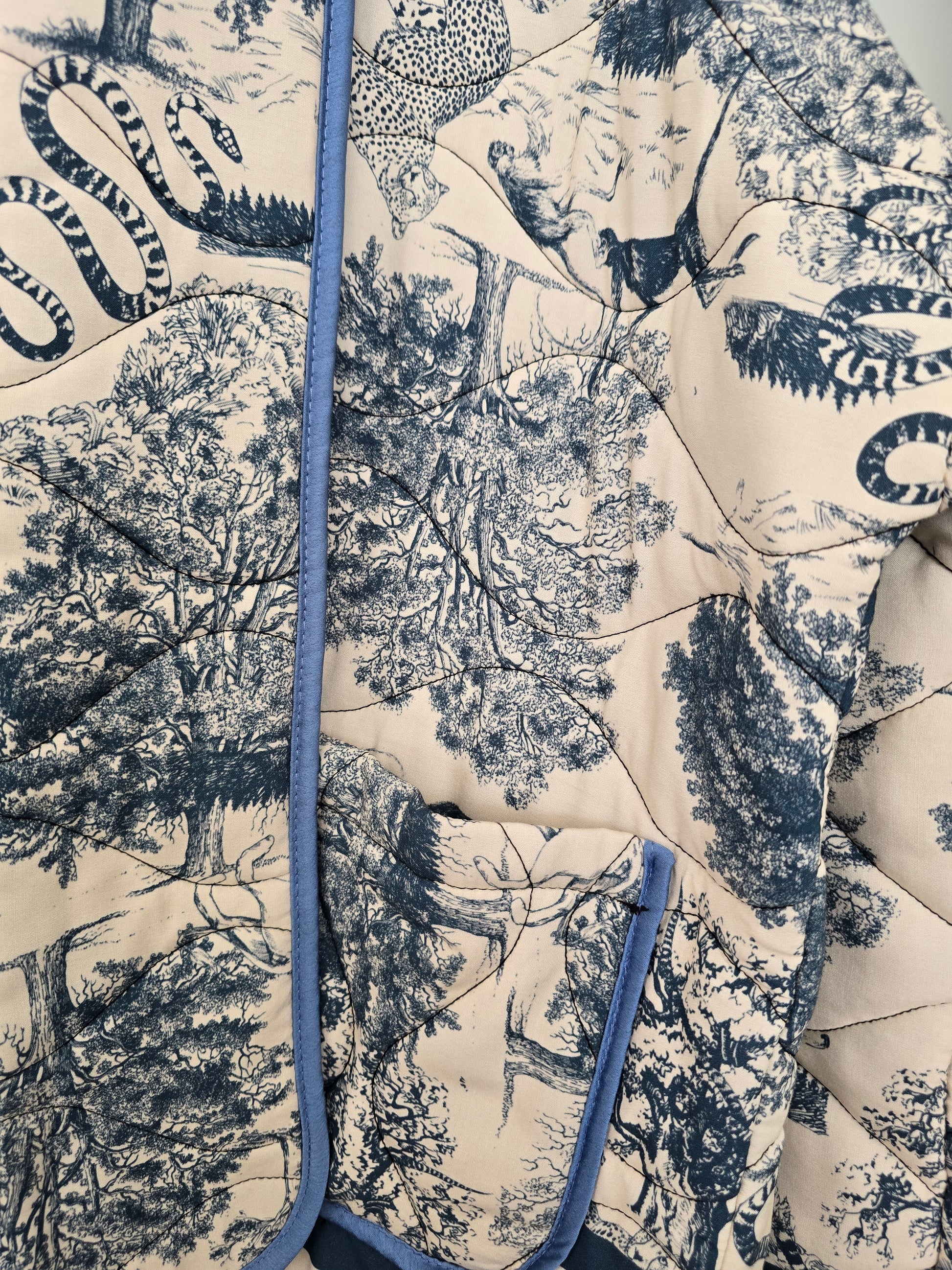 Exklusive Steppjacke in Blau-Weiß mit elegantem Toile-de-Jouy Safari-Design. Hochwertig gesteppt, modern geschnitten und ein stilvoller Blickfang für trendbewusste Looks.